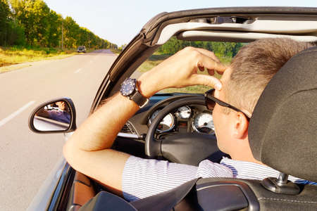Illness, exhausted, disease, tired for overworked concept. businessman having headache from migraine while he driving car. young man holds his hand over his head in a car.の写真素材