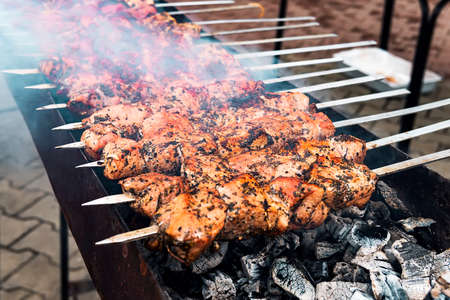 Hot grilled pork kebab or barbecue kebab on charcoal background with herbs and spices close up. Photo barbecued pork cubes decorated with hot pepperの写真素材