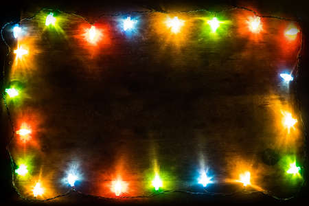 New Year's background. Christmas background Christmas garland with colored lights and lamps on a wooden background. Free space for textの写真素材