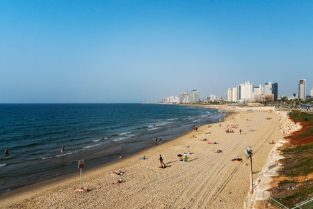 Panoramic view of beach of Tel Aviv shot at a fine sunny day, Israel. Panoramic view of city waterfront with sandy shore and not numerous people swimming in the mediterranean sea. Summertime in cityのeditorial素材