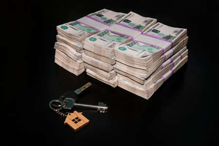 bundle of five thousand notes with keys to an apartment or house on a white background. Buying real estate for Russian money.の写真素材