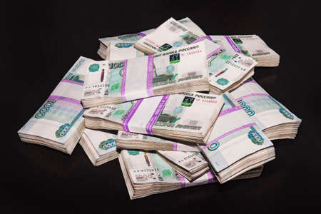 Bank of Russia money tickets are 1000 rubles background. A lot of money laid out in bundles of 100,000 rubles on a black background.の写真素材