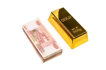 A gold bar and a wad of 5000 banknotes are isolated on a white background.