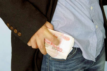 Russian money in the pocket of jeans. Banknote 5000 rubles. The concept of finance. Close-up. man put bills in his pocket. Salary.の写真素材