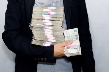 large stack of paper money in the hand of an adult businessman. The concept of financial success. a lot of money in men's handsの写真素材