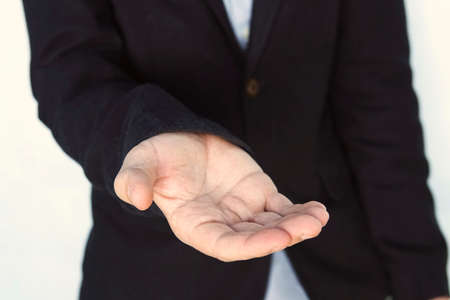 empty workpiece. Gesture of alms begging. Businessman stretches out his hand. An adult young man asks for money. elegant gentleman lend a helping handの写真素材