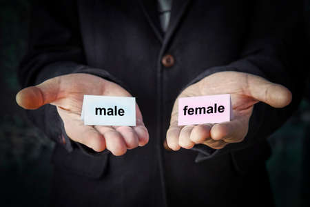 Sex selection at birth. Sex change. Choice of sexual orientation. concept. Tablets with inscriptions male and female in different hands.の写真素材