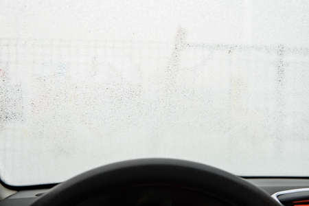 frost on the windshield of the car. View from the driver's side. a frozen car windshieldの写真素材