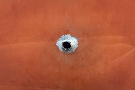 hole with black center in the iron plate. external bullet holeの写真素材
