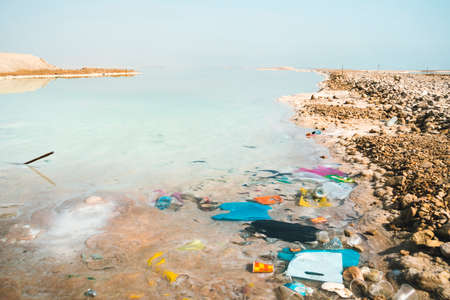 Garbage in salt water on the shore of the dead sea. Pollution of natural monuments. Environmental...
