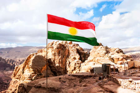 Flag of the unrecognized Republic of Kurdistan in the mountains against the sky and nature of the...
