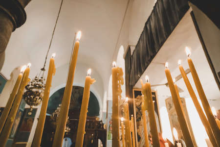 Lighting candles in the church and praying. Prayer Orthodox candles. Rite of passage in the Church.の写真素材