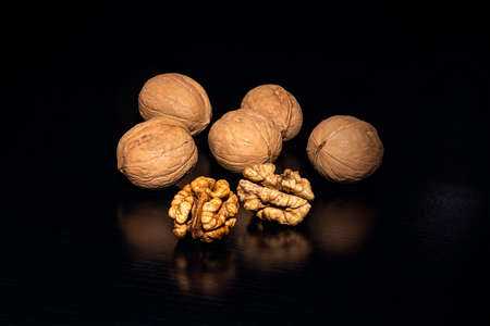 Walnuts on black background. walnut with reflection. nut kernels and whole nuts.