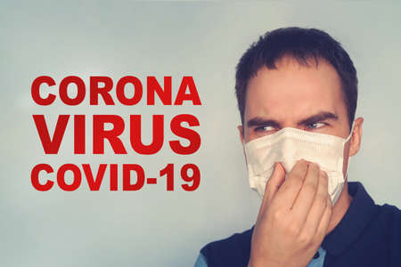 A young man looks at the words coronavirus. Fear and danger of covid-19 infection. concept of...