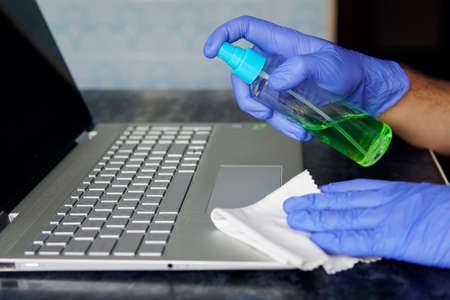 man panic cleaning notebook laptop pc. cleaning the dust from the keys on the gray keyboard....