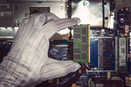 RAM Memory cards for notebook. Random access memory for replacement to laptop computer. RAM module DDR in hand on the background of a modern notebook-transformer. ultrabook upgradeの写真素材