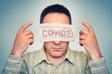 The man hides his eyes behind a medical mask marked Corvette. The concept of fatigue from global...