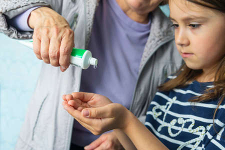 child girl using alcohol antiseptic gel, prevention, cleaning hands frequently, prevent infection, outbreak of Covid-19, girl wash hands with hand sanitizerの写真素材