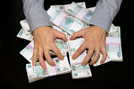 Lust for money. Large stack of banknotes, Russian rubles, banknotes 1000 rubles. hands are grabbing...