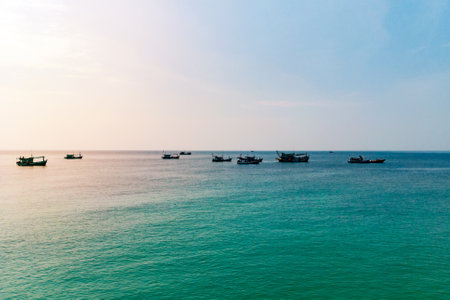 Traditional wooden boat in Cambodia. Sunrise sea landscape photo. Sea and sky view with boat silhouette. Koh Rong island seashore. South Asia vacation card.のeditorial素材