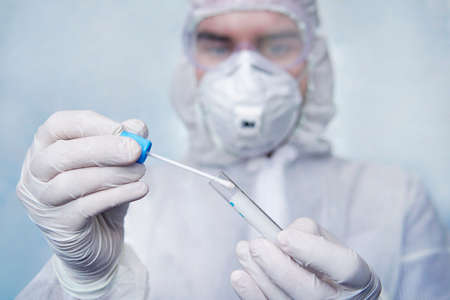 Examination of mucosal smears. The scientist is holding a test tube. Study of viruses in sputum of...