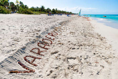 Sea landscape with inscription Varadero, city is a resort in the Caribbean with a beautiful long beach. tourists in the background.の写真素材