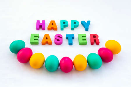 Colored Easter eggs and Happy Easter inscription on the table