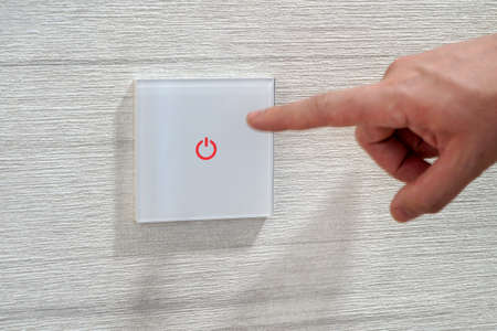 save energy concept,closeup of finger touching to electric switch. mans finger presses a...