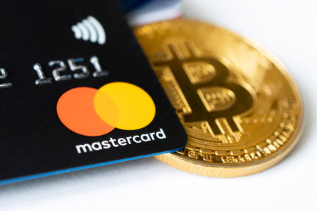 Gold bitcoin symbol and credit card master cards on the table. February 20, 2021, Barnaul, Russiaのeditorial素材