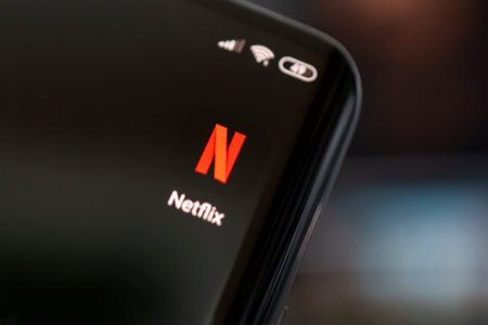 Close-up of cell phone with netflix logo on screen. Netflix is an international leading subscription...