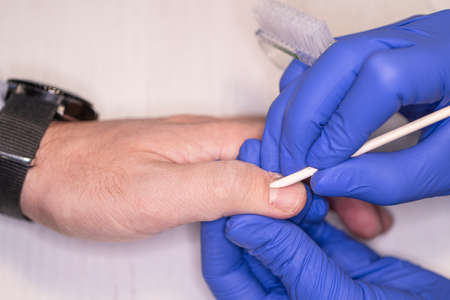 Man gets his manicure done, hands closeup. In a men's beauty salon.