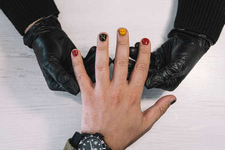Process of coloring nails on men's fingers in a beauty salon. Manicurist girl gives a guy a manicure. Man manicure. close upの写真素材