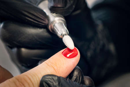 Men's manicure. Design of men's manicure. The master makes a man manicure. The concept of professional nail care. Close-up of the manicurist's hands at work. A man does a manicure.の写真素材