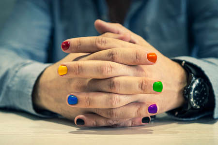 A man with painted nails. Design of male nails. men manicure. The nails are painted in the color of the rainbow.の写真素材