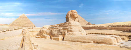 The iconic Sphinx carving adjacent to the Great Pyramids at Giza, Egypt. The great ancient Sphinx on a blue background. side viewの写真素材
