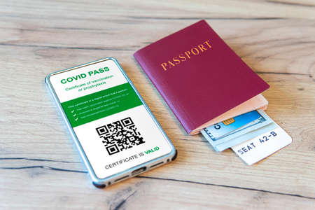 A passport and a smartphone with a Certificate of Vaccinationの写真素材
