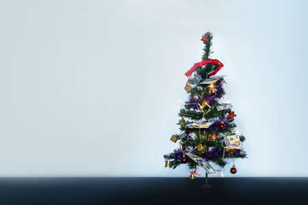 Hundred dollar bills. Money on Christmas tree. Small decorated Christmas tree on a blue background. copy space for text and designの写真素材