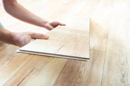 Laying laminate flooring, closeup. replacement of damaged laminate flooring. Renovation in the apartment. Choice of parquetの写真素材