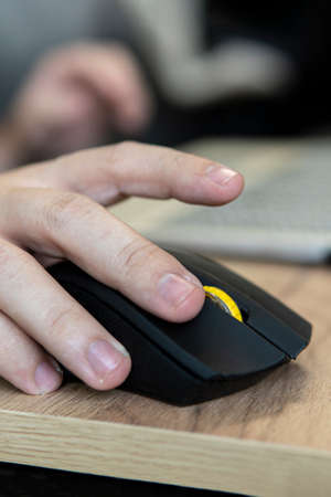 Businessman wearing elegant suit and using computer mouse in closeup at desk in office. Making money...