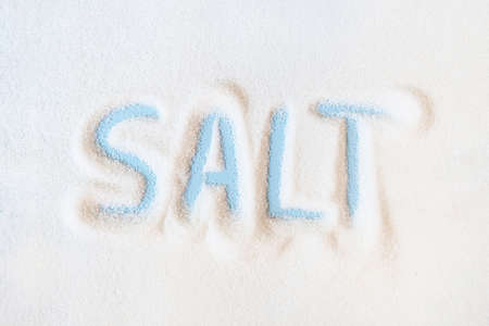 The blue word Salt on a background of scattered salt crystalsの写真素材