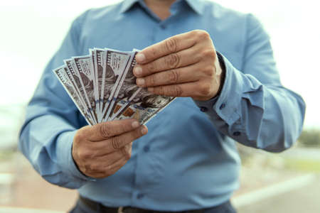 Businessman with money on nature on a blure background