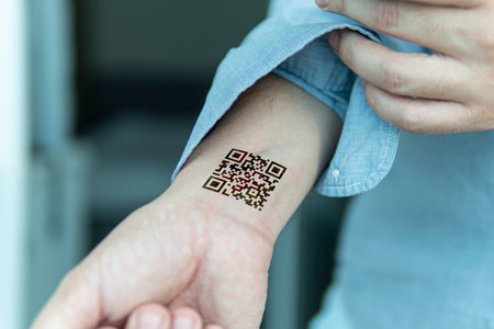 QR code on the person's wrist. The concept of chipping a person to control or simplify the work with personal data, close-up.のeditorial素材