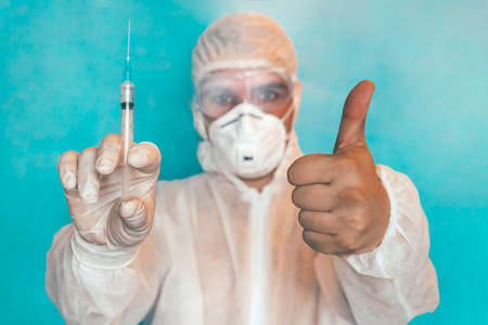 Close up of scientist interacting with syringe liquid vaccine in laboratory. doctor is showing the...