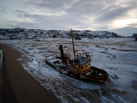 An old abandoned ship on the shore of the Barents Sea in the Arctic Ocean. top view, aerial view,. The destroyed economy and industry of Russia concept,の写真素材