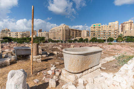 Ancient Roman artifacts at the excavations against the background of modern houses in the city Alexandria. Egypt. Attractions.の写真素材