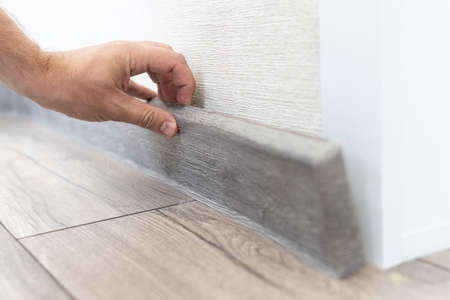 installing the floor skirting board. dismantling of the plastic skirting board. selective focus on...