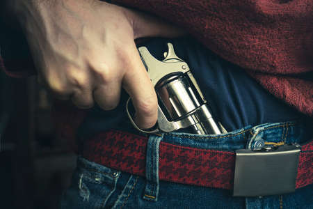 street crime concept. a man robs on the street. The search of the criminal, the man pulls a gun out...
