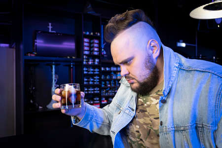 drunk brutal man with an alcoholic cocktail in a glass. The concept of bad habits and alcohol...