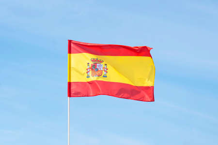 Spain flag on the bluec loudy sky with clipping path. close up waving flag of Spain. flag symbols of...