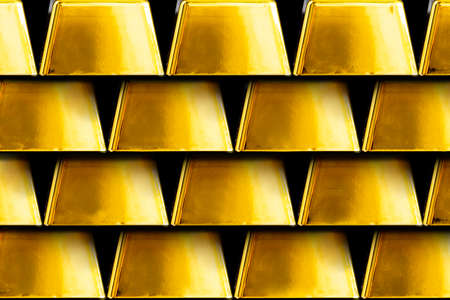 Gold bars next to each other on a black background. Shiny precious metal for investment or as a...